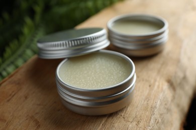 Photo of Natural solid perfume and plant on wood, closeup