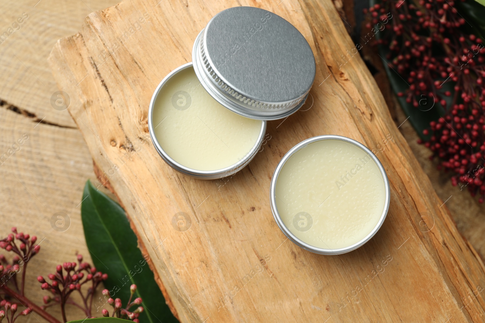 Photo of Natural solid perfume and skimmia plant on wood, top view