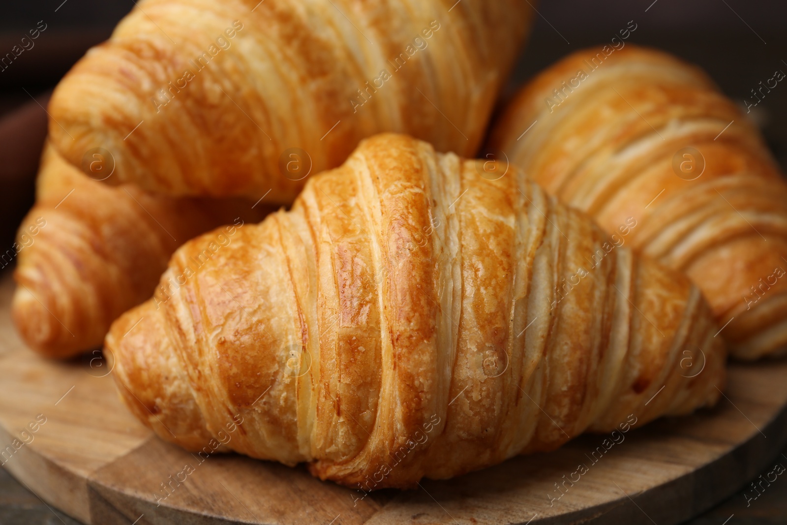 Photo of Tasty fresh croissants on table, closeup. Puff pastry