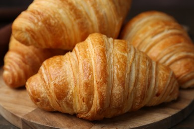 Photo of Tasty fresh croissants on table, closeup. Puff pastry