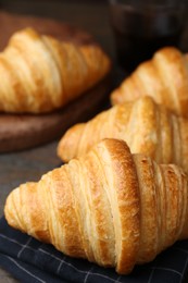 Photo of Tasty fresh croissants on wooden table, closeup. Puff pastry