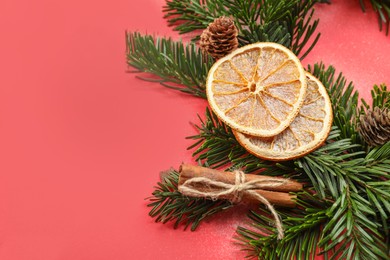 Photo of Different spices, dried orange slices and fir tree branches on red background, closeup with space for text. Christmas season