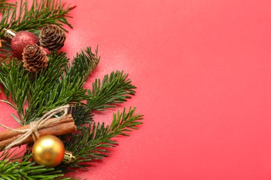 Photo of Different spices, dried orange slices and fir tree branches on red background, flat lay with space for text. Christmas season