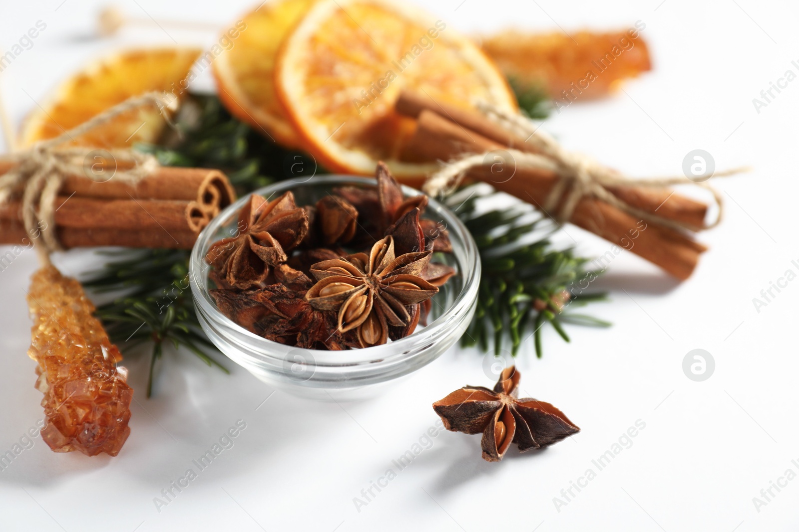 Photo of Different spices, dried orange slices and fir tree branches on white table, closeup. Christmas season