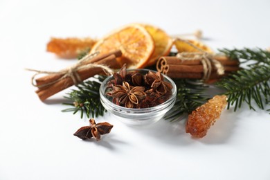 Photo of Different spices, dried orange slices and fir tree branches on white table, closeup. Christmas season