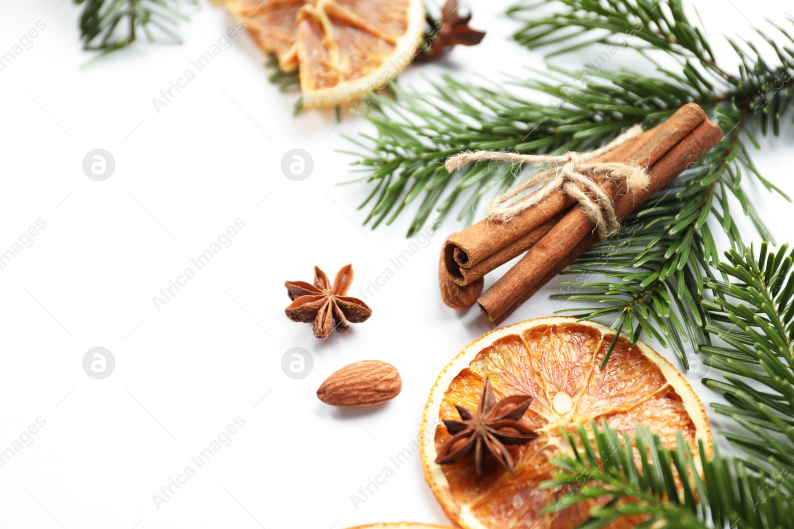 Photo of Different spices, dried orange slices and fir tree branches on white table, closeup with space for text. Christmas season