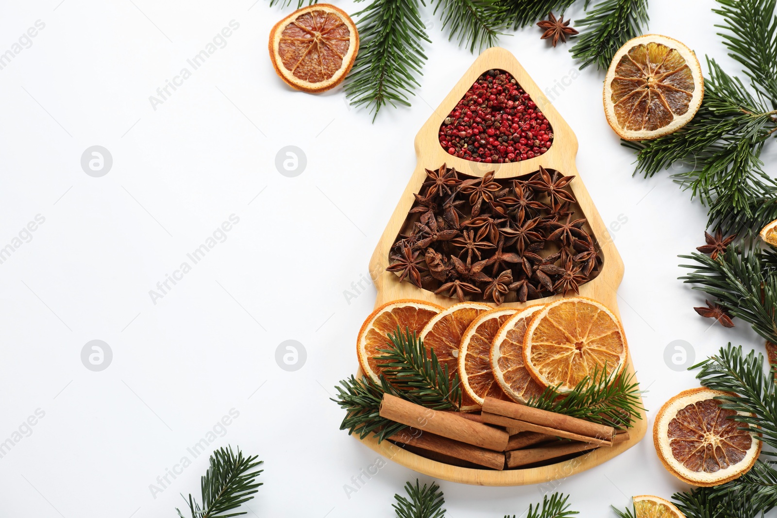 Photo of Different spices, dried orange slices and fir tree branches on white table, flat lay with space for text. Christmas season