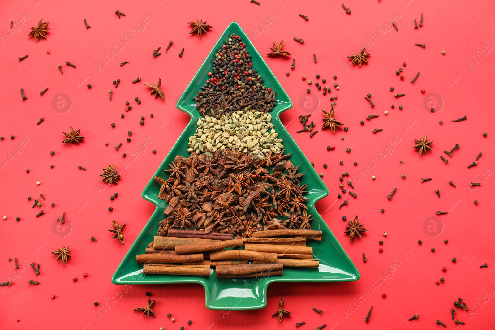 Photo of Different spices on red background, flat lay. Christmas season