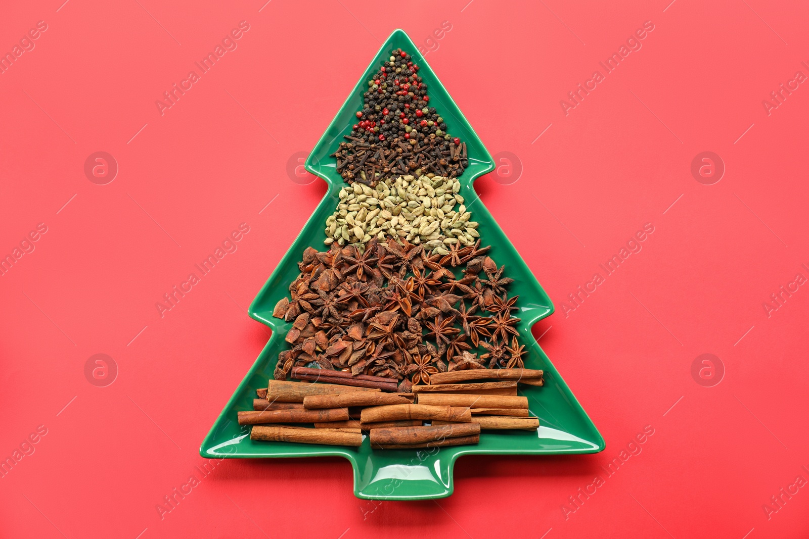 Photo of Different spices on red background, top view. Christmas season