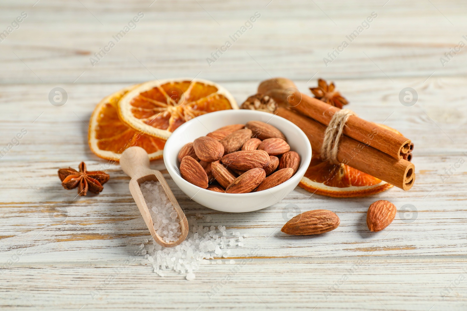 Photo of Different spices and dried orange slices on white wooden table. Christmas season