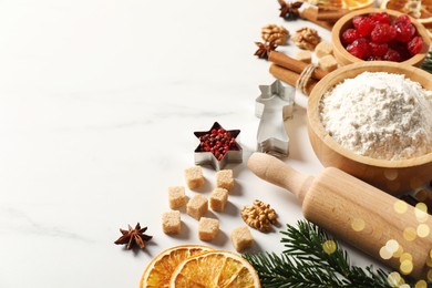 Photo of Different aromatic spices and fir tree branches on white table, space for text. Christmas season