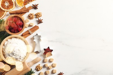 Photo of Different aromatic spices and fir tree branches on white table, flat lay with space for text. Christmas season