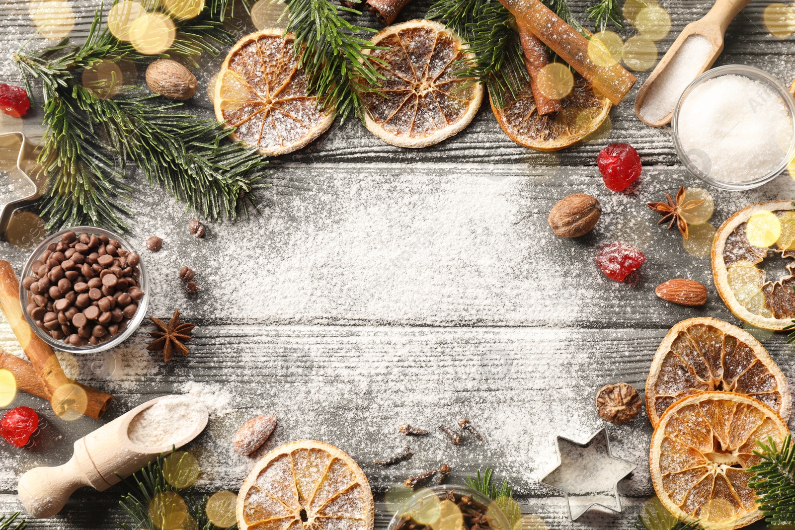 Photo of Frame of different aromatic spices and fir tree branches on wooden table, flat lay with space for text. Christmas season