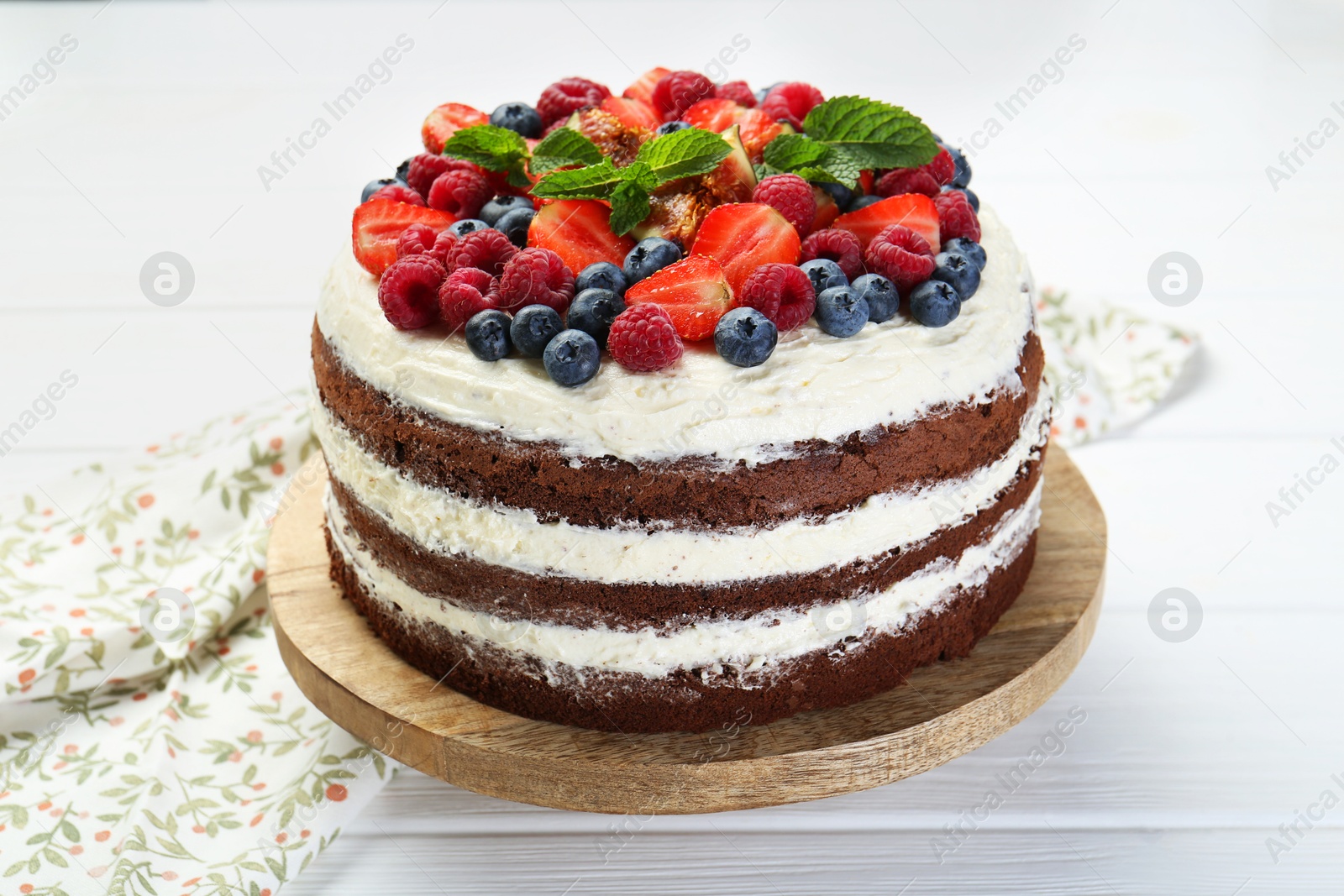 Photo of Delicious chocolate sponge cake with berries on light table