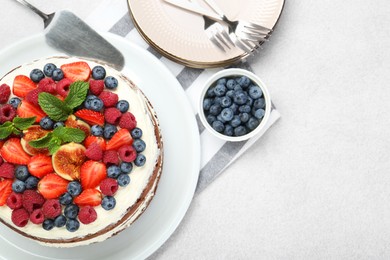 Photo of Delicious chocolate sponge cake with berries served on light table, flat lay. Space for text