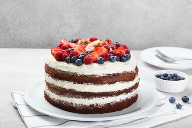 Photo of Delicious chocolate sponge cake with berries on light table