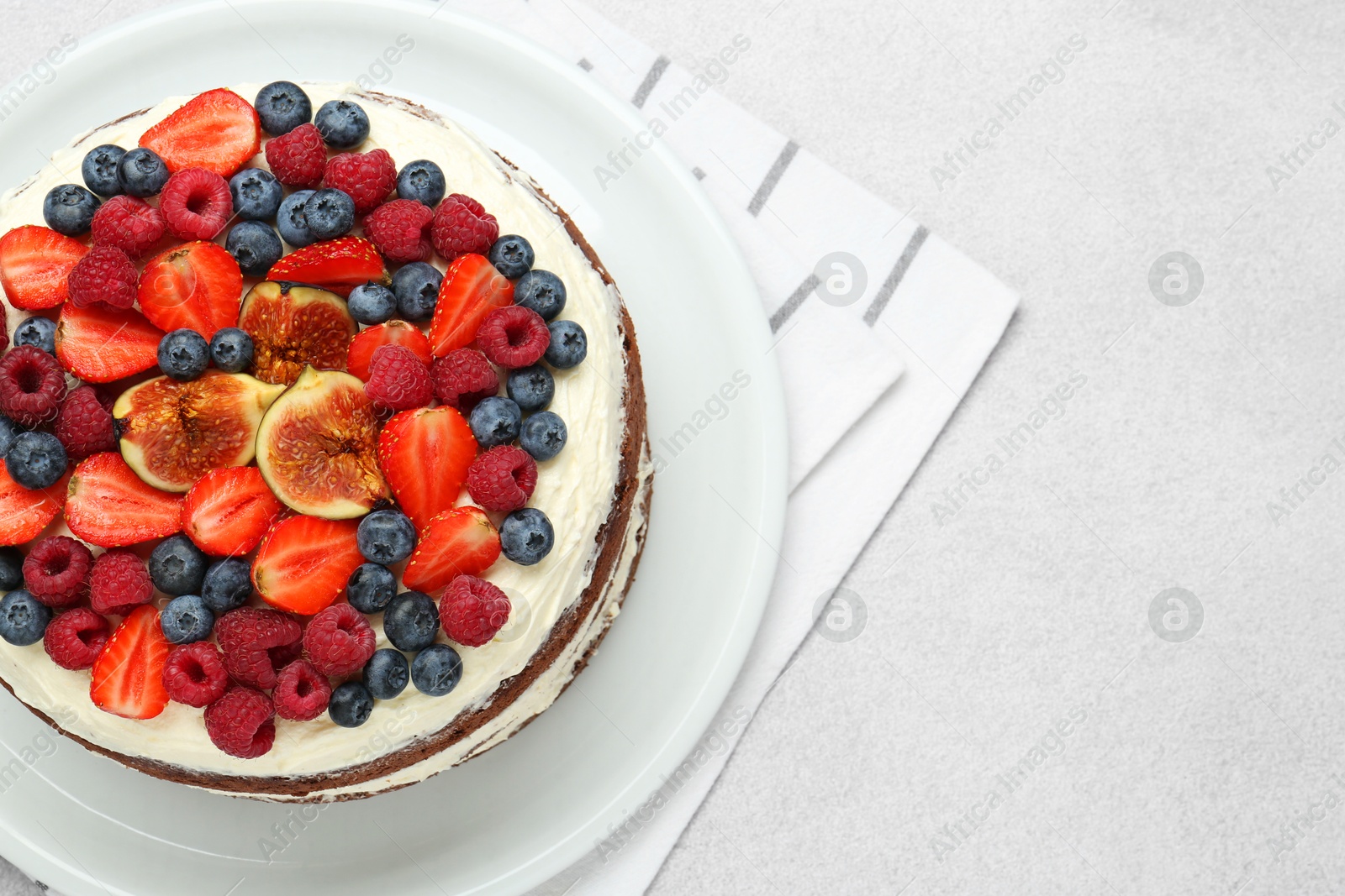 Photo of Delicious chocolate sponge cake with berries on light table, top view. Space for text