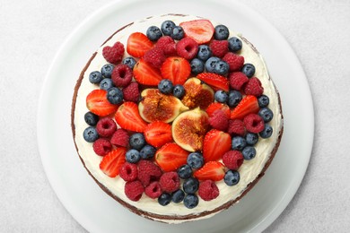 Photo of Delicious chocolate sponge cake with berries on light table, top view