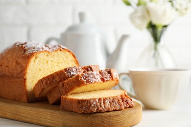 Photo of Freshly baked sponge cake on white wooden table, closeup