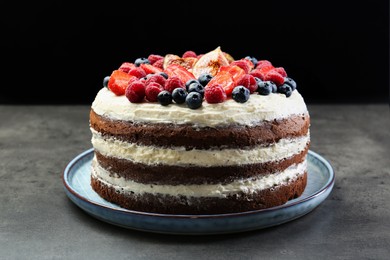 Photo of Delicious chocolate sponge cake with berries on grey table, closeup