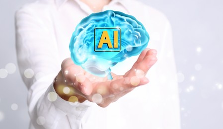 Image of Artificial intelligence. Woman holding virtual brain with AI abbreviation on white background, closeup. Banner design