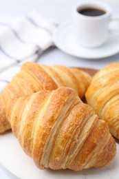 Photo of Tasty fresh croissants on light table, closeup. Puff pastry