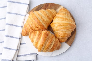 Photo of Tasty fresh croissants on light grey table, top view