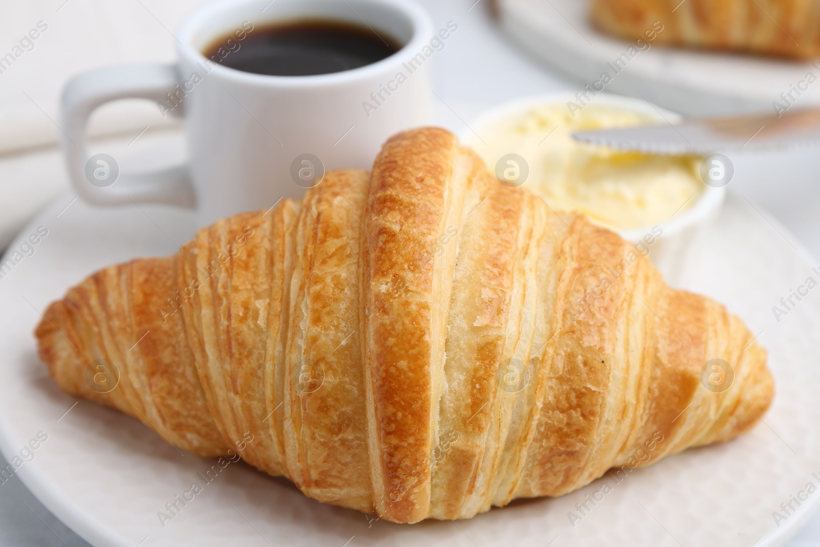 Photo of Tasty fresh croissant served on white table, closeup