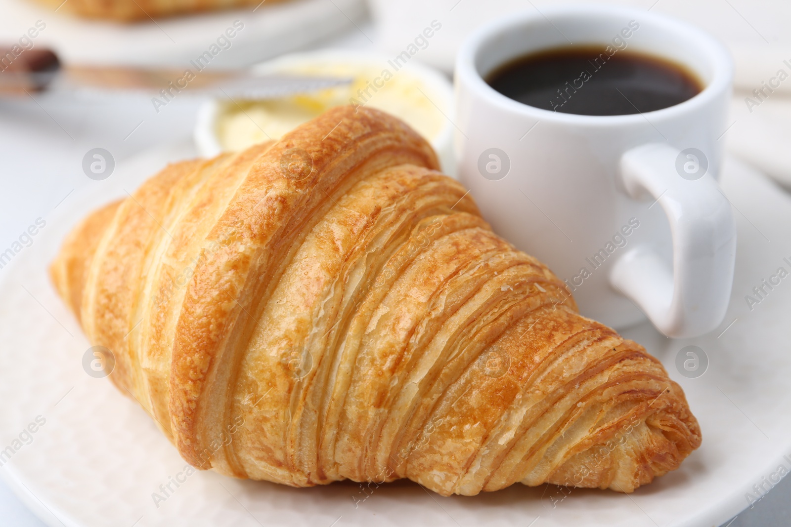 Photo of Tasty fresh croissant served on white table, closeup