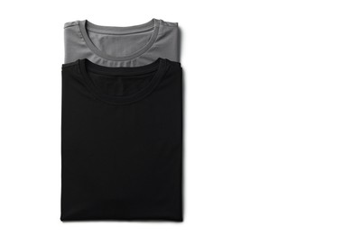 Image of Black and grey t-shirts on white background, top view. Mockup for design