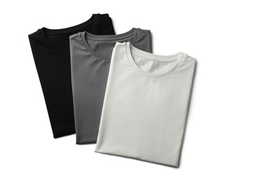 Image of Black, white and grey t-shirts on white background, top view. Mockup for design