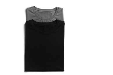 Image of Black and grey t-shirts on white background, top view. Mockup for design