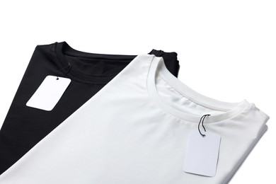 Image of Black and white t-shirts with tags on white background. Mockup for design