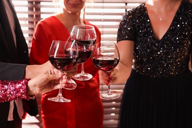 Photo of People clinking glasses of red wine at party, closeup