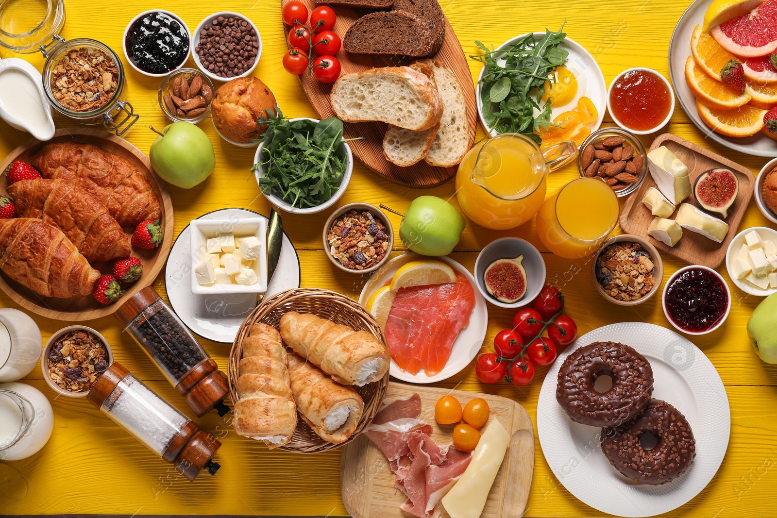 Photo of Different tasty food served for brunch on yellow wooden table, flat lay