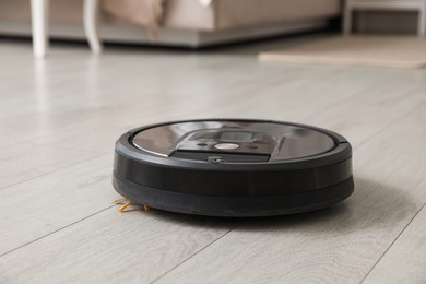 Photo of Robotic vacuum cleaner on wooden floor indoors