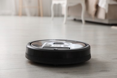 Photo of Robotic vacuum cleaner on wooden floor indoors