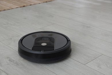 Photo of Robotic vacuum cleaner on wooden floor indoors