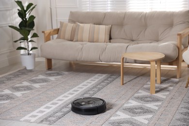 Photo of Robotic vacuum cleaner on floor in living room