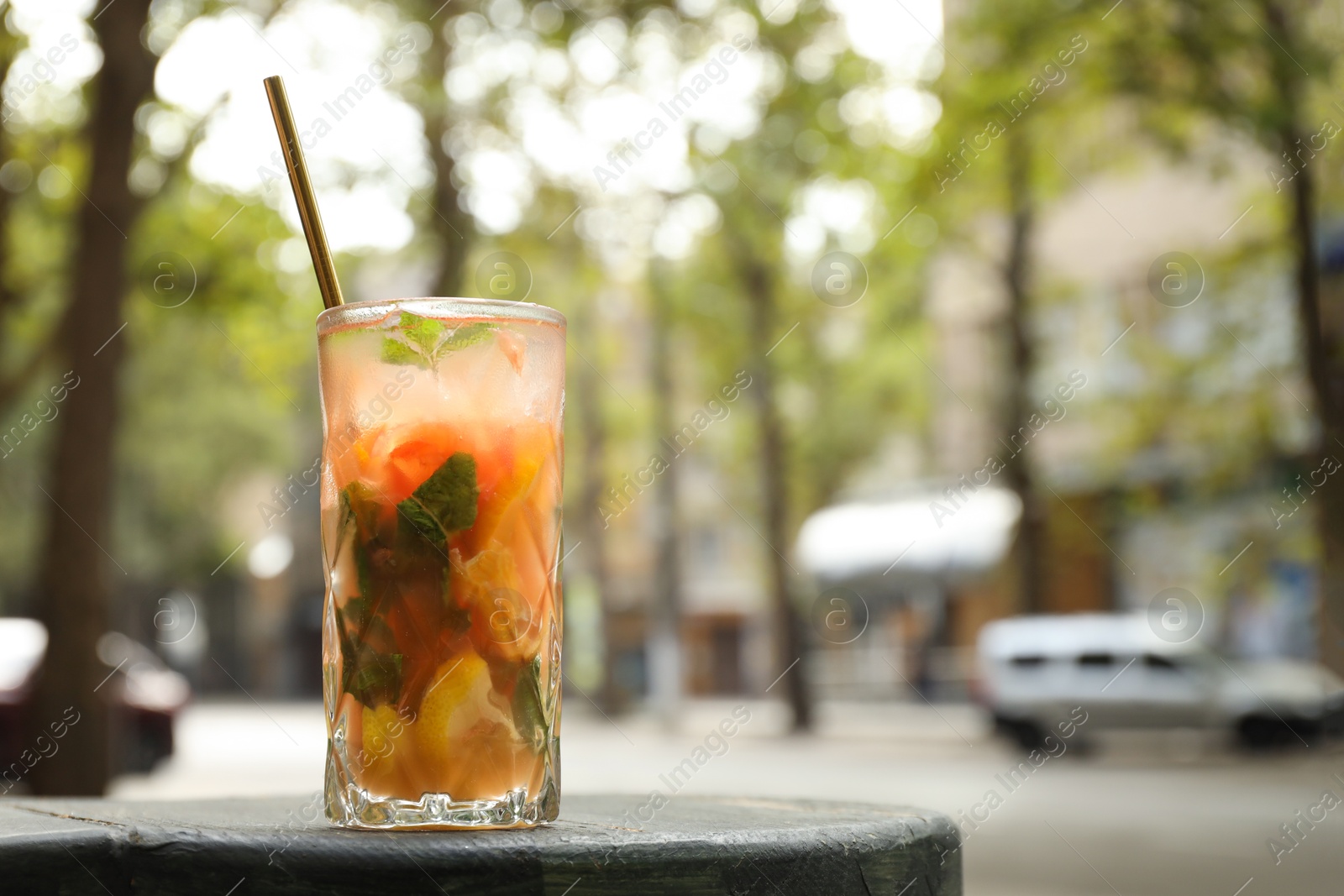 Photo of Glass of tasty refreshing drink and straw on table, space for text