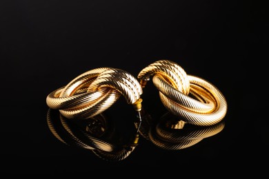 Photo of Beautiful bijouterie. Stylish earrings on black background