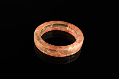 Photo of Beautiful bijouterie. Stylish ring on black background