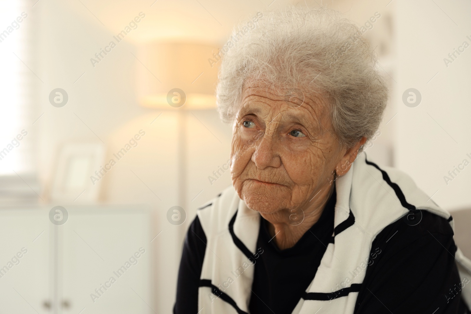 Photo of Loneliness concept. Sad senior woman at home