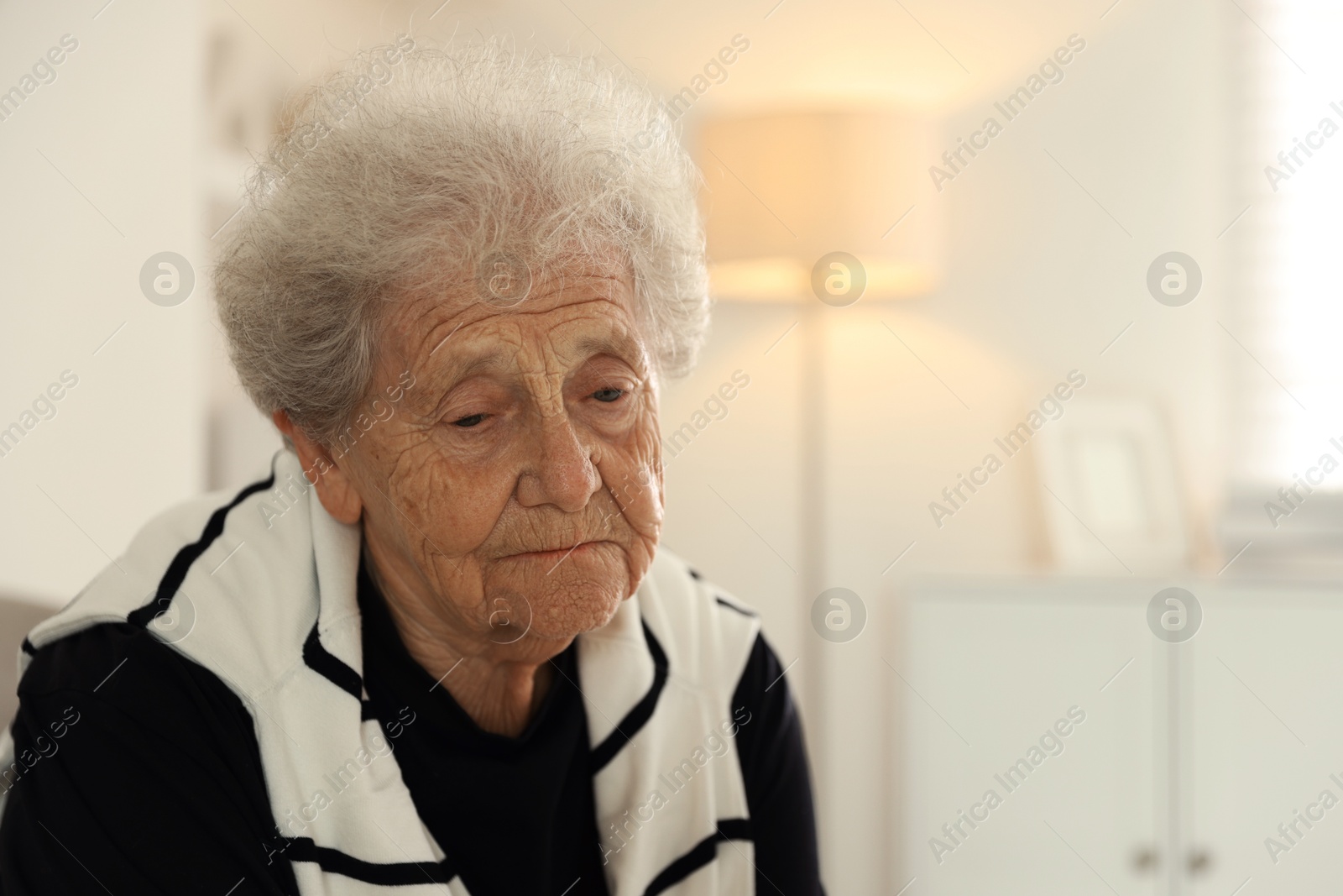 Photo of Loneliness concept. Sad senior woman at home