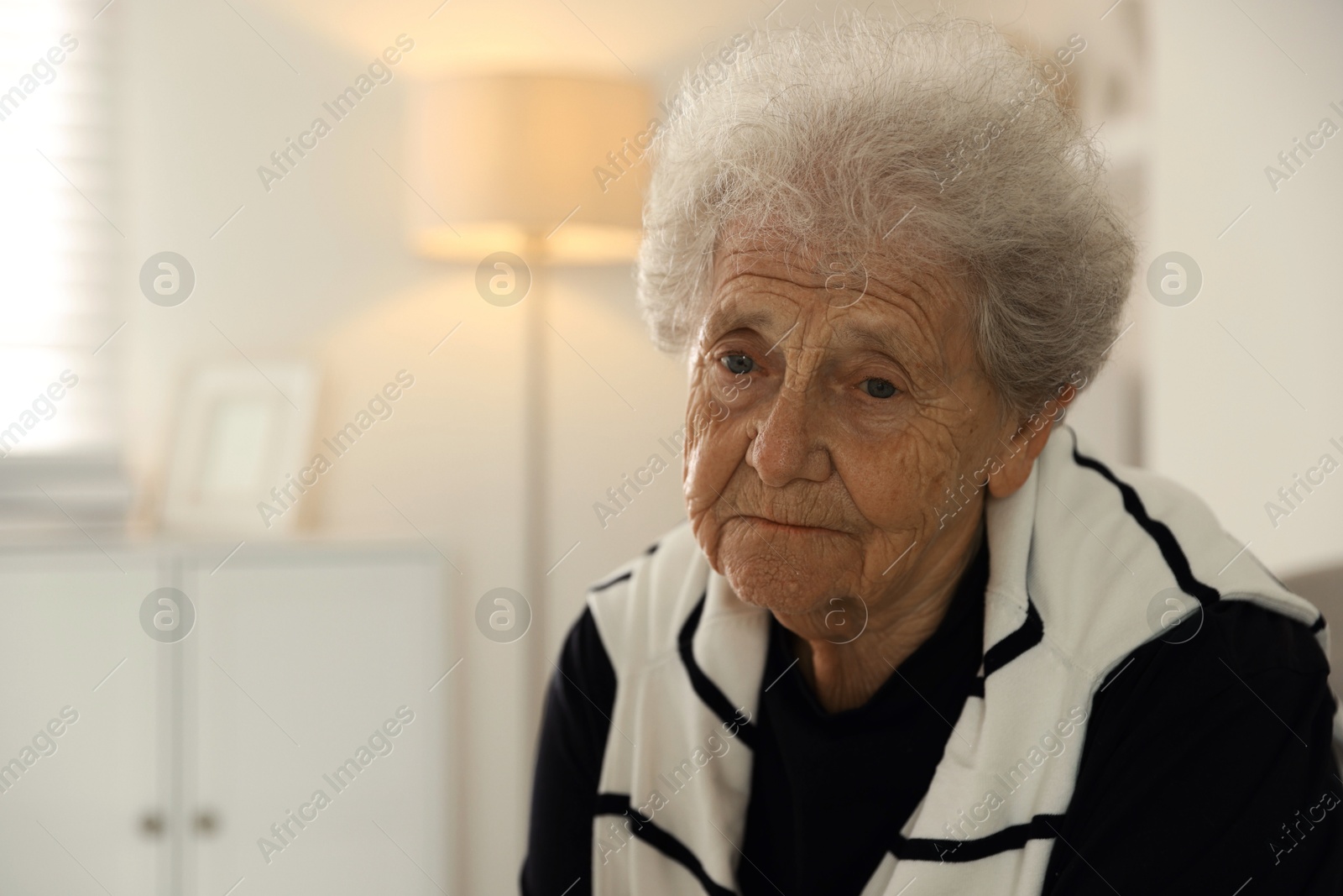 Photo of Loneliness concept. Sad senior woman at home