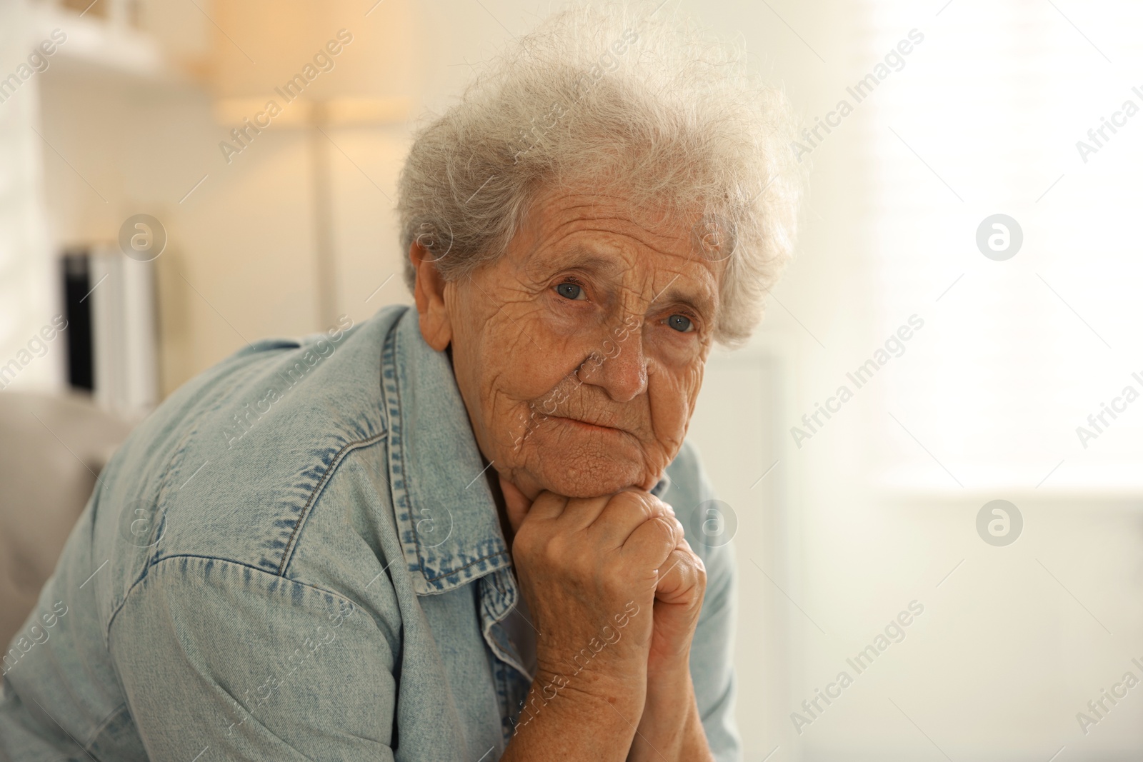 Photo of Loneliness concept. Sad senior woman at home