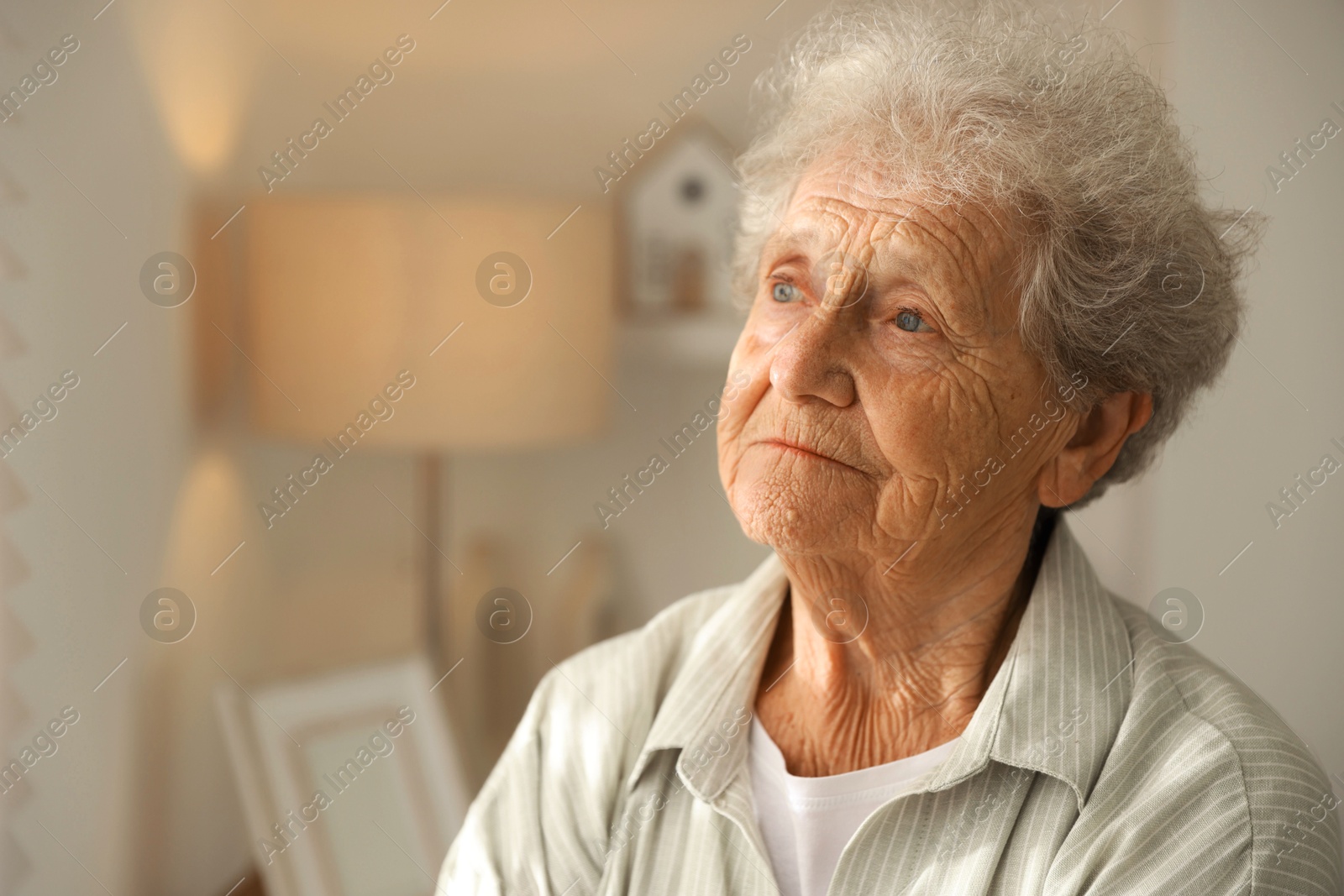 Photo of Loneliness concept. Sad senior woman at home