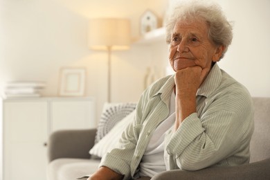 Photo of Loneliness concept. Sad senior woman sitting on sofa at home