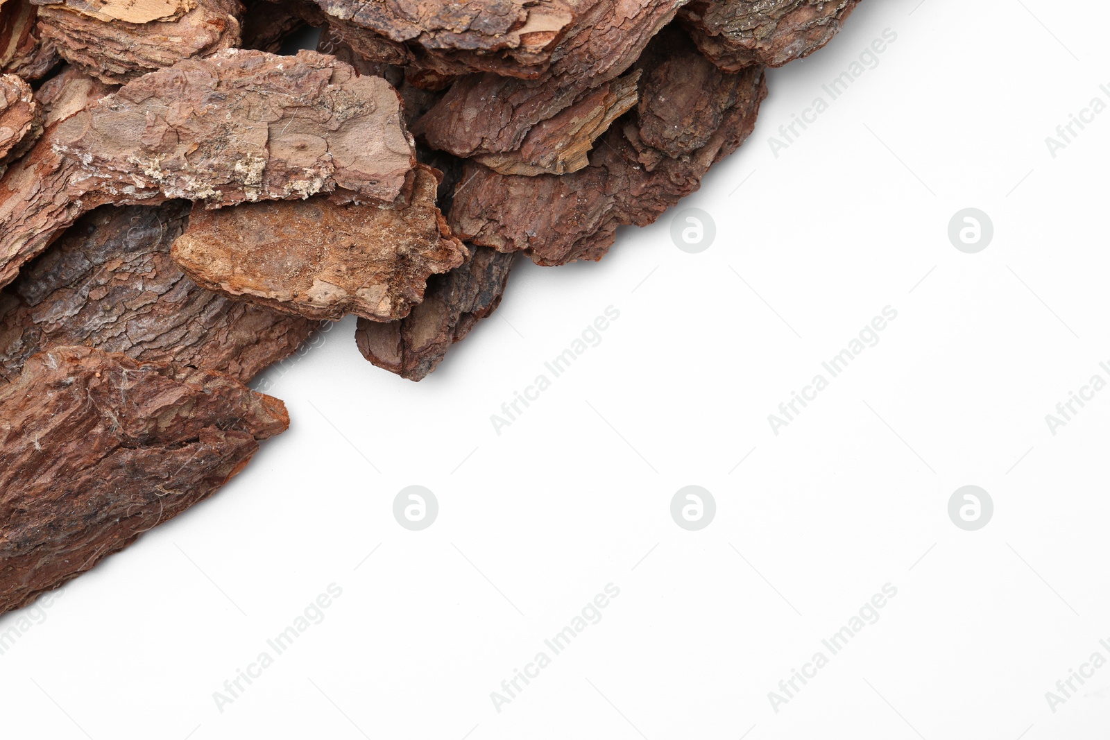 Photo of Pieces of tree bark on white background, top view. Space for text