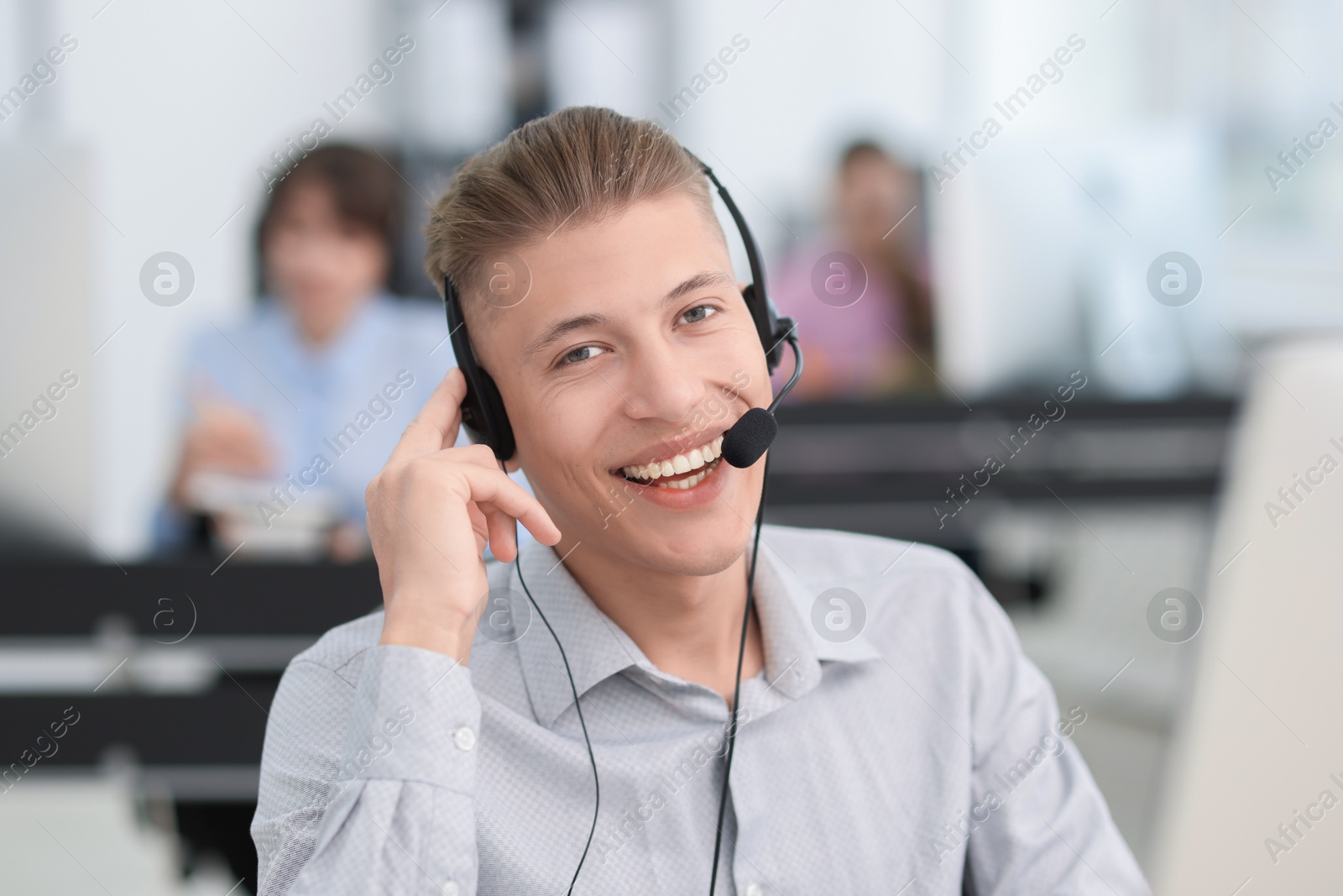 Photo of Salesman talking to client via headset in office